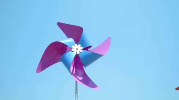 Colorido aerogenerador girando por soplado de viento, espacio para el texto — Vídeo de stock