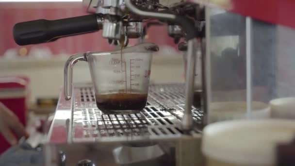 Свежий жареный кофе втиснут в мерную чашку — стоковое видео