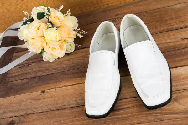 Wedding bouquet with groom's shoes on wood background — Stock Photo, Image