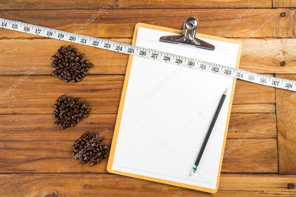 Wooden Clipboard attach planning paper with pencil beside coffee