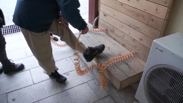 Sopradores de uso turístico limpeza de poeira de seus sapatos — Vídeo de Stock