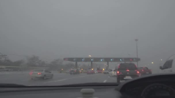 Rain splatters car windshield during storm while passing the toll to highway — Stock Video