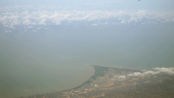 View from the top, above the clouds, rural and seaside scene below — Stock Video