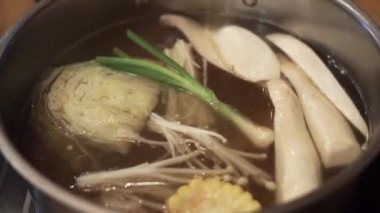 Sukiyaki Pot sıcak su ile çiğ gıda koymak