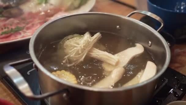 Rohkost in Sukiyaki-Topf mit heißem Wasser geben — Stockvideo