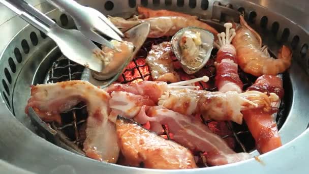 Koreaanse barbecue kachels met chacoal, rauwe garnalen, mosselen, vis, spek binnen — Stockvideo