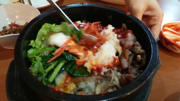 Miscelazione di bibimbap in ciotola di pietra riscaldata, piatto coreano — Video Stock