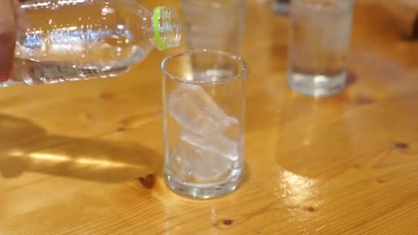 Hälla vatten från en plastflaska i ett glas — Stockvideo