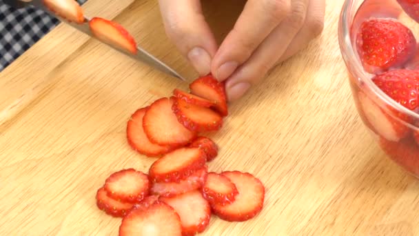 Een aardbeien snijden in dunne stukjes, traag — Stockvideo