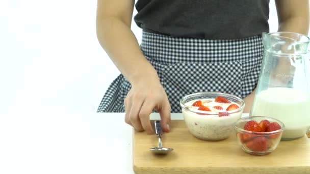 Breakfast, pick up spoon, scoop cereal with strawberries, ready to eat — Stock Video