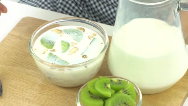 Breakfast, pick up spoon, scoop cereal with kiwis, ready to eat, slow — Stock Video