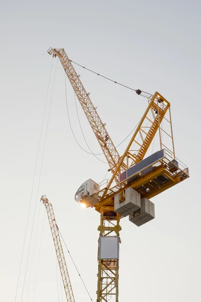 Construction site, workers and cranes.