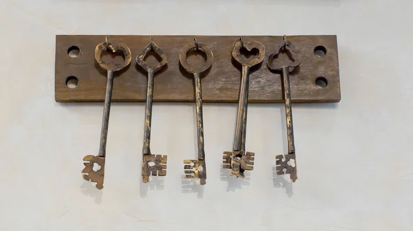 Old keys with key hanging on a white wall of an old hotel — Stock Photo, Image