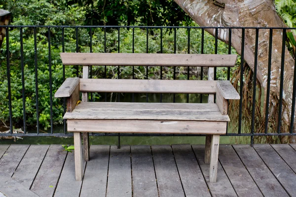 Holzbank auf der Terrasse mit Blick auf den grünen Baum — Stockfoto