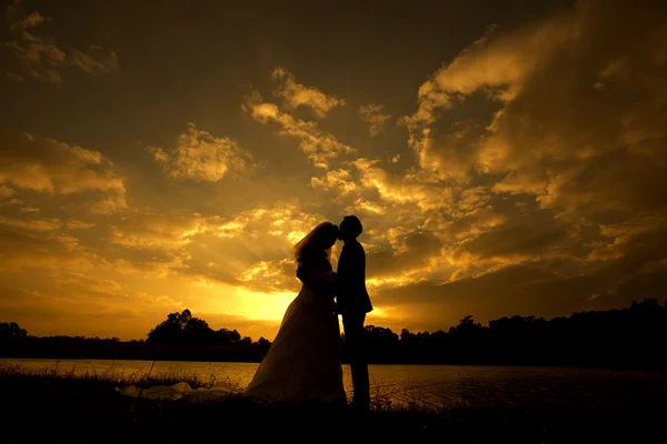 Silhouet bruidspaar met zonsondergang — Stockfoto