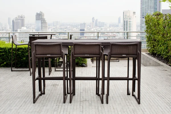 Rattan oone table with two stool chairs standing against the ter — Stock Photo, Image