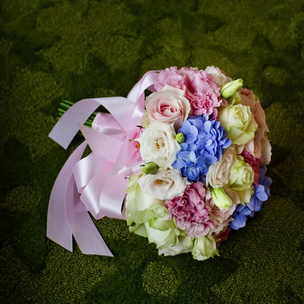 Boeket van bloeiende kleurrijke bloemen op een groene tapijt pagina — Stockfoto