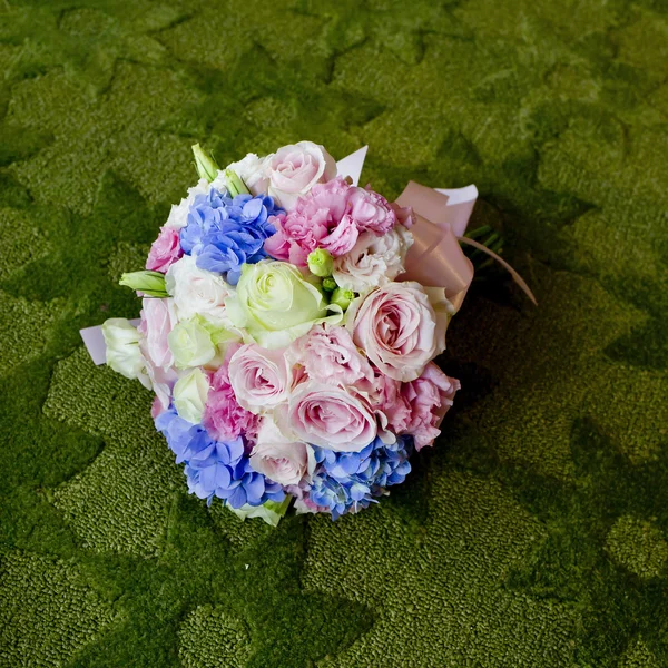 Ramo de flores de colores florecientes en un fondo de alfombra verde — Foto de Stock