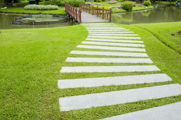 Stenen blockera promenad väg i parken med grönt gräs bak — Stockfoto