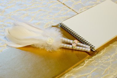 Photo of a wedding register and feather pen. Wedding guestbook. clipart