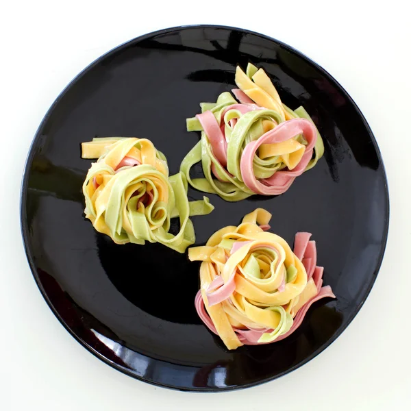 Three color pasta on black dish ready to served — Stock Photo, Image