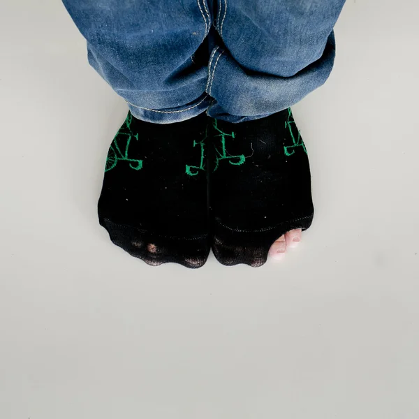 Worn out socks with a hole and toe sticking out of them on white — Stock Photo, Image