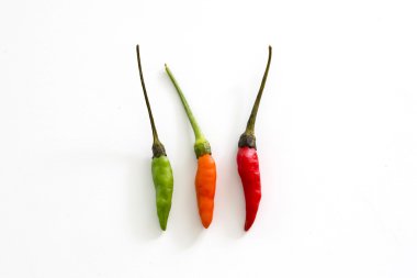 Beyaz arka plan üzerinde kırmızı, yeşil ve turuncu kırmızı biber