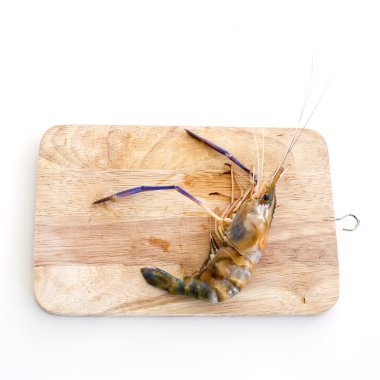 Beyaz ahşap masa üzerinde kesme tahtası üzerinde kaplan karides