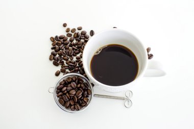 Kahve fincanı ve beyaz arka plan üzerinde kahve çekirdeği