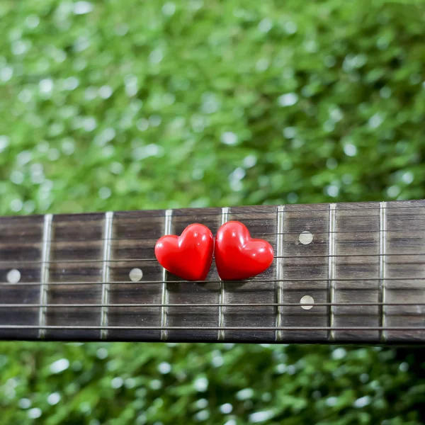 Heart on neck guitars and strings on the grass — Stock Photo, Image