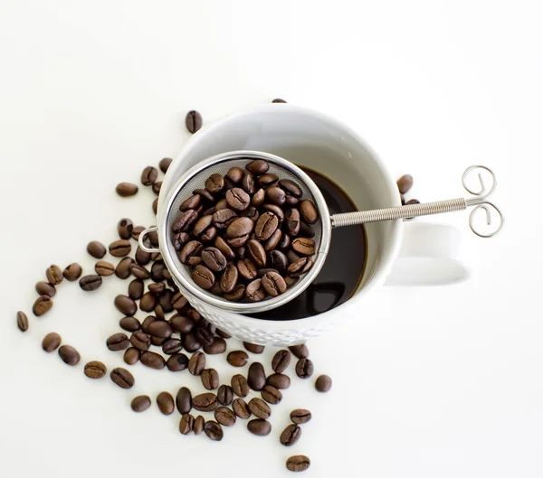 Xícara de café e grão de café no fundo branco — Fotografia de Stock