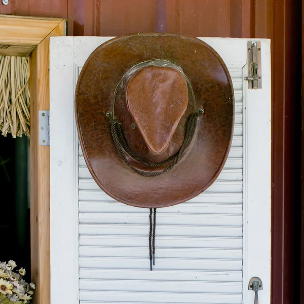 Chapéu de cowboy pendurado em uma porta de madeira — Fotografia de Stock