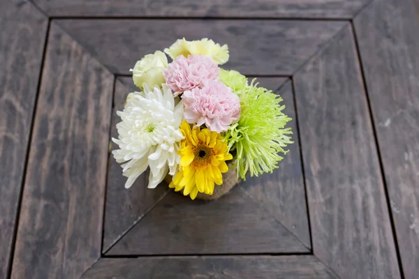 Een kleine boeket van kleurrijke bloemen op een goed gebruikt oude bureau of w — Stockfoto