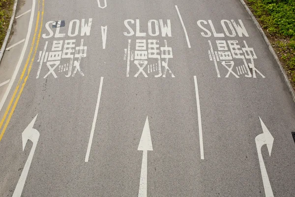 Bilingüe (inglés y chino) Señal de tráfico lento para conductor —  Fotos de Stock