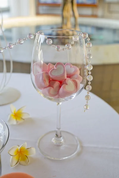 Decoración de mesa de boda. caramelo de forma de corazón en copa de vino . — Foto de Stock