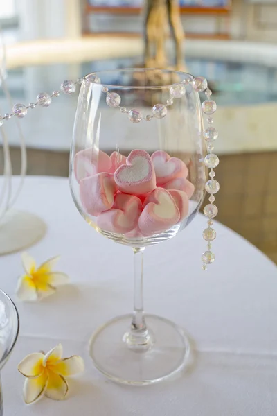 Decoración de mesa de boda. caramelo de forma de corazón en copa de vino . — Foto de Stock