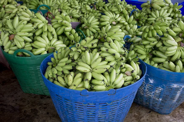 Muitas bananas verdes em cesto pronto para vender no mercado — Fotografia de Stock