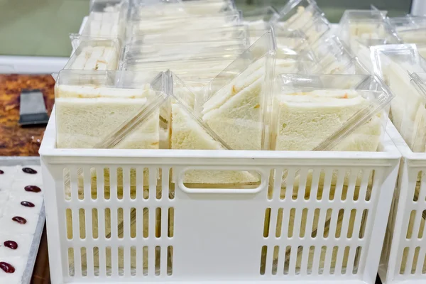 Schotel van sandwich driehoeken snijden in plastic doos klaar voor verkopen — Stockfoto