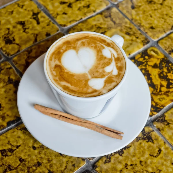 A cup of cafe latte and Cinnamon stick. — Stock Photo, Image