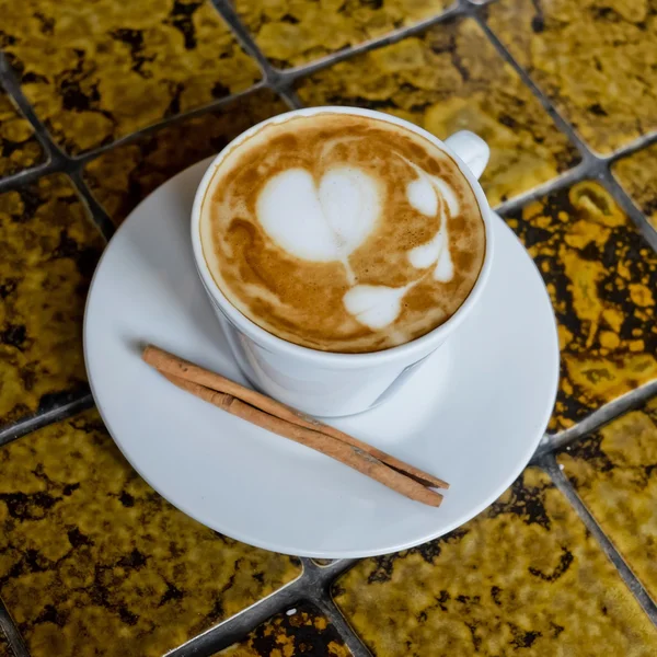 A cup of cafe latte and Cinnamon stick. — Stock Photo, Image