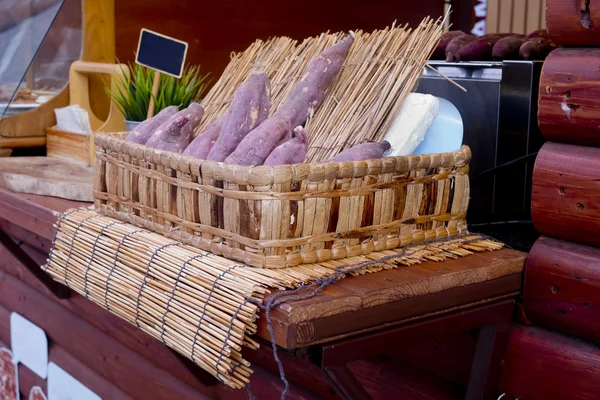 Sweet potato with wood skewer ready to roasted — Stock Photo, Image