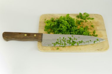 bıçak ile kesme tahtası üzerinde kıyılmış maydanoz