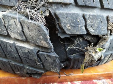 Yırtık araba lastiği yakın çekim. Büyük delik.