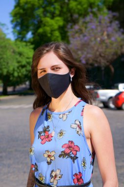 Kadın açık havada maske takıyor.
