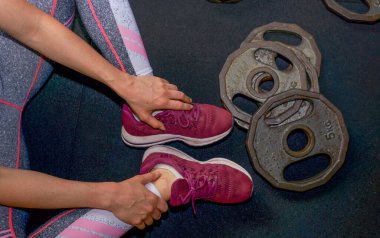 Spor salonunda çeşitli egzersizler yapan genç bir kadın.