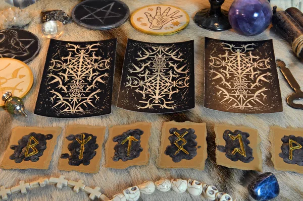 Tarot cards and runes with magic ritual objects and crystals on witch table. Esoteric, gothic and occult background, Halloween mystic concept.