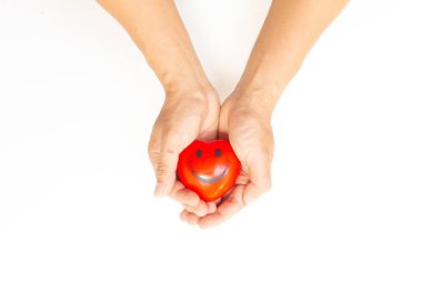 Beyaz arka planda kırmızı bir kalp tutan eller