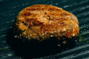 Hamburg eti tavada kızartılıyor. Hamburgerin ana malzemelerinden biri..