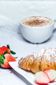Kontinentální snídaně s croissanty. Káva a čerstvé jahody
