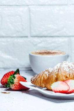 Kruvasan ile Avrupalı kahvaltı. Kahve ve taze çilek.